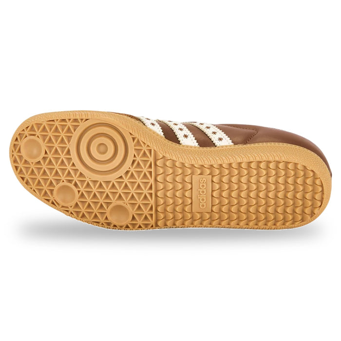 Close-up of a brown sneaker sole with white stripes on a white background
